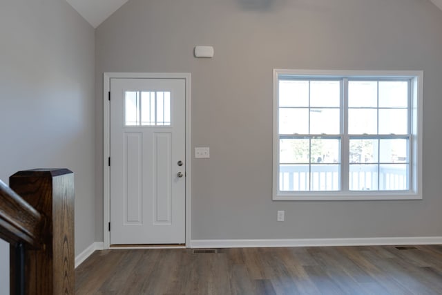 foyer entrance with plenty of natural light, dark hardwood / wood-style floors, and vaulted ceiling