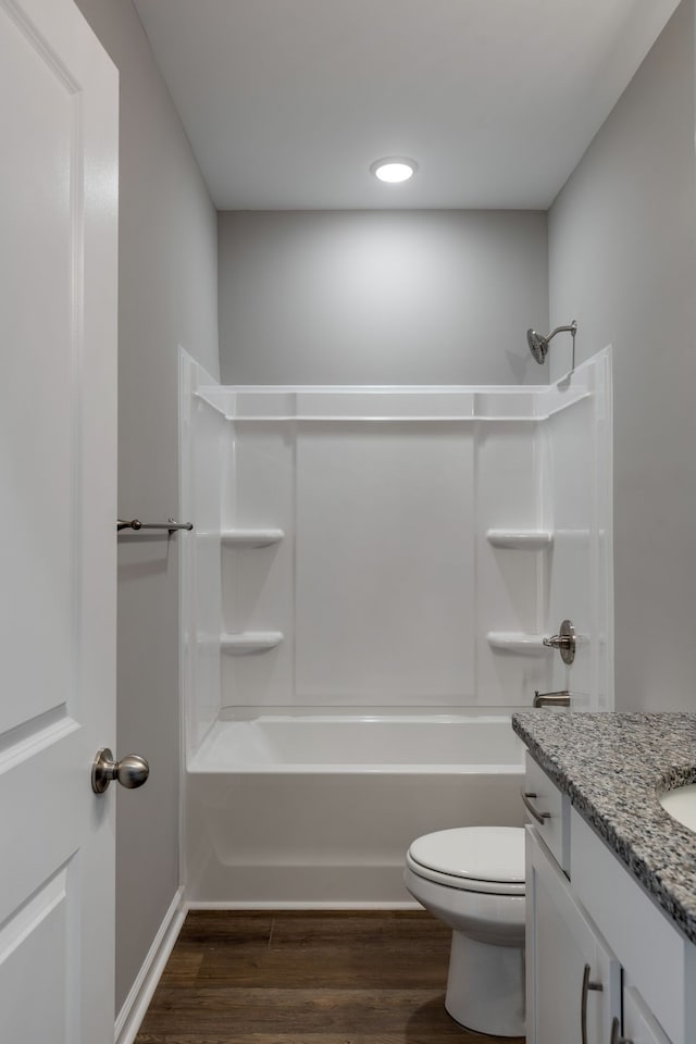 full bathroom featuring hardwood / wood-style floors, vanity, toilet, and shower / washtub combination