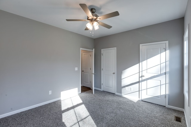 spare room with ceiling fan and carpet