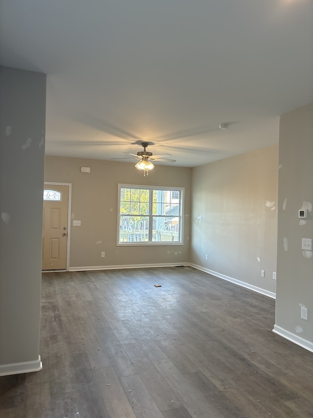 unfurnished living room featuring ceiling fan and dark hardwood / wood-style flooring