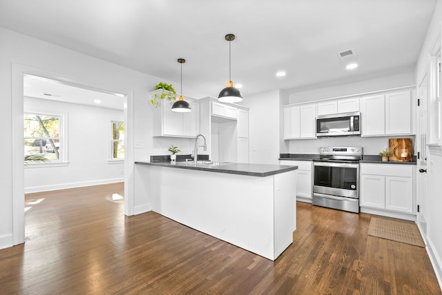 kitchen featuring stainless steel appliances, sink, pendant lighting, white cabinets, and dark hardwood / wood-style flooring