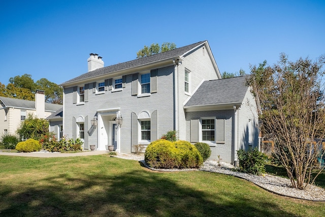 colonial-style house featuring a front lawn