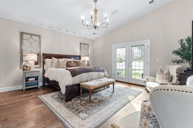 bedroom with hardwood / wood-style flooring, access to exterior, an inviting chandelier, high vaulted ceiling, and french doors