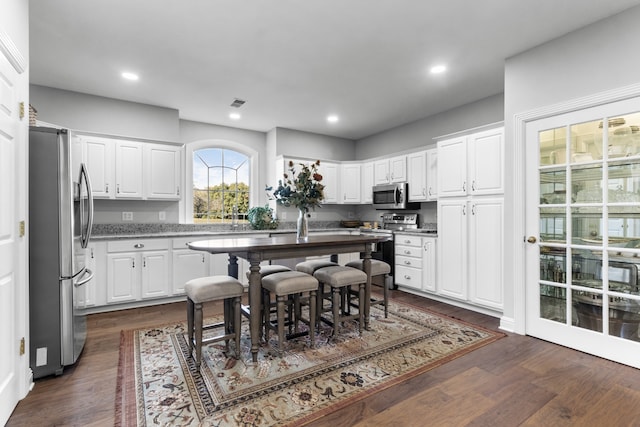 kitchen featuring white cabinetry, appliances with stainless steel finishes, and dark hardwood / wood-style flooring