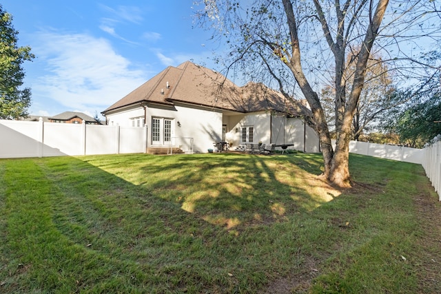 back of property featuring a lawn and french doors