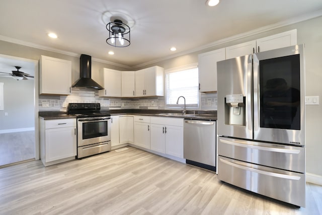 kitchen featuring stainless steel appliances, wall chimney range hood, sink, and white cabinets