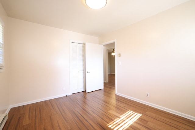 spare room with dark wood-type flooring and baseboard heating