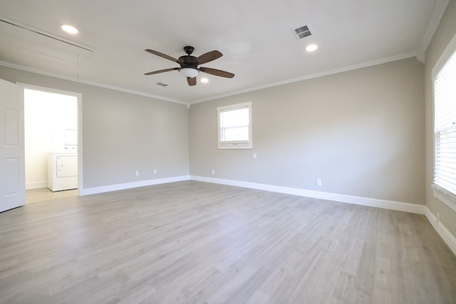 empty room with washer / dryer, ornamental molding, and light hardwood / wood-style floors