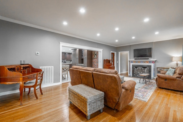 living room featuring ornamental molding and light wood-type flooring