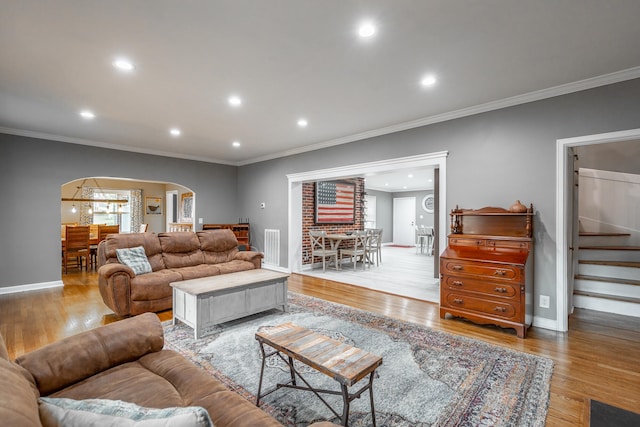 living room with crown molding and light wood-type flooring