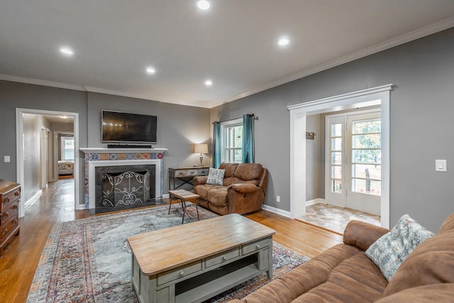 living room with ornamental molding and light hardwood / wood-style flooring