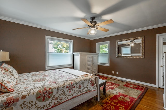 bedroom with dark wood-type flooring, ceiling fan, and crown molding