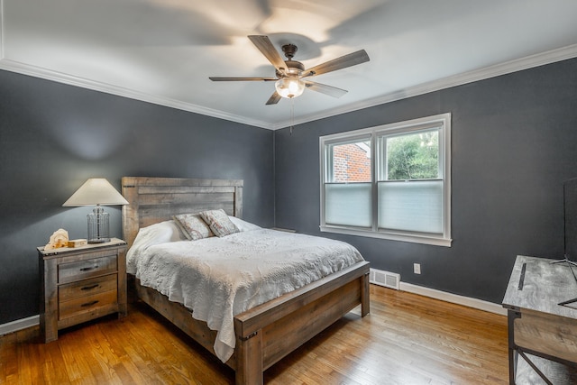 bedroom with crown molding, light hardwood / wood-style flooring, and ceiling fan