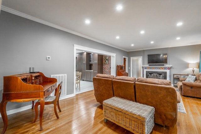 living room with ornamental molding and light hardwood / wood-style flooring