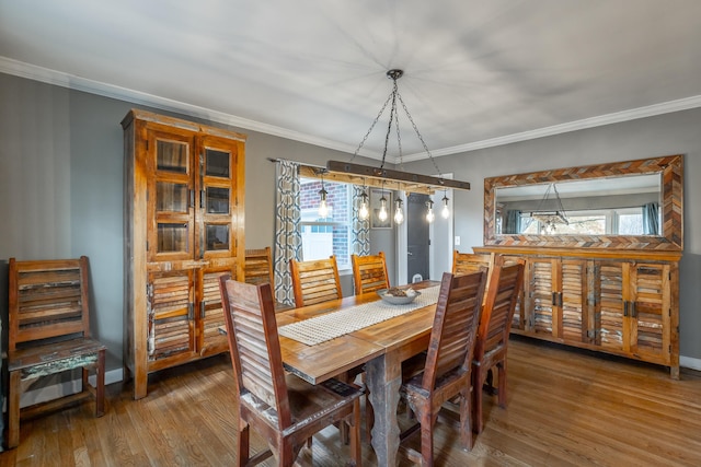 dining space featuring a wealth of natural light, ornamental molding, and wood-type flooring