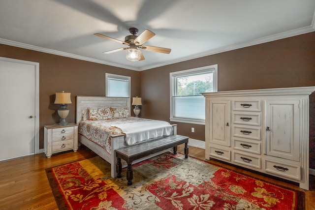 bedroom with hardwood / wood-style floors, crown molding, and ceiling fan