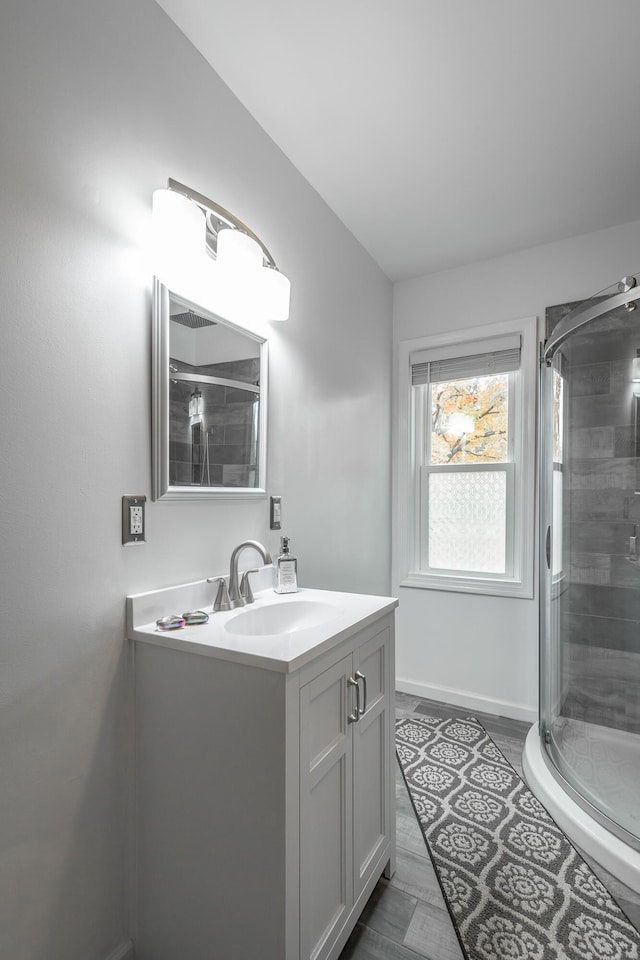 bathroom featuring vanity and a shower with door