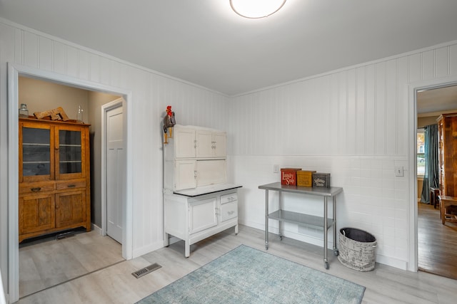 miscellaneous room with crown molding and light hardwood / wood-style flooring