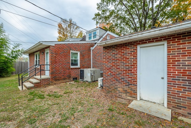 rear view of house with a yard and central AC unit