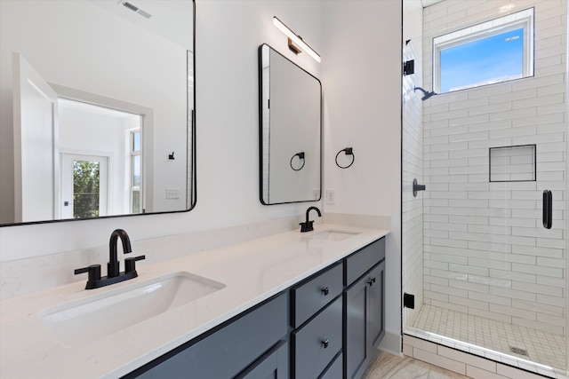 bathroom with vanity, a healthy amount of sunlight, and a shower with shower door