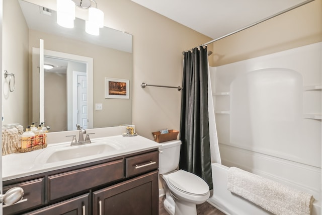 full bathroom with shower / bathtub combination with curtain, hardwood / wood-style flooring, vanity, and toilet