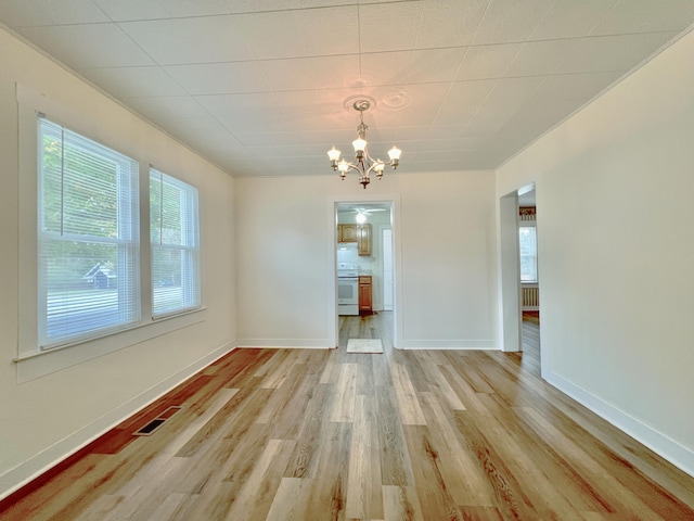 unfurnished dining area featuring light hardwood / wood-style flooring and a chandelier