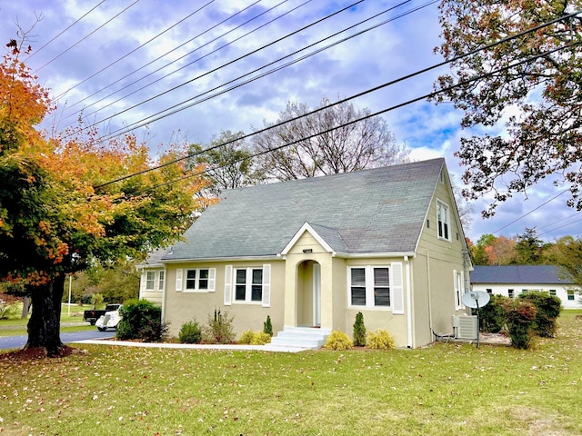 view of front of house featuring a front lawn and central AC unit