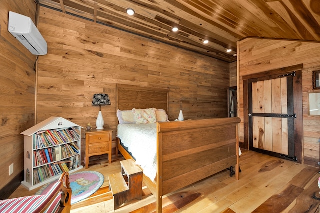 bedroom with a wall mounted AC, wooden walls, vaulted ceiling, and light wood-type flooring