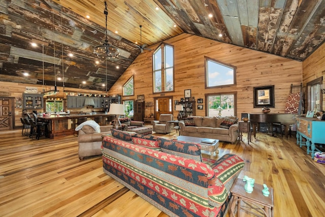 living room featuring light hardwood / wood-style floors, high vaulted ceiling, a chandelier, and wood ceiling