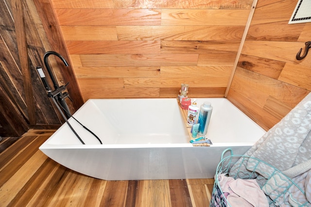 bathroom with wood-type flooring and a bathtub