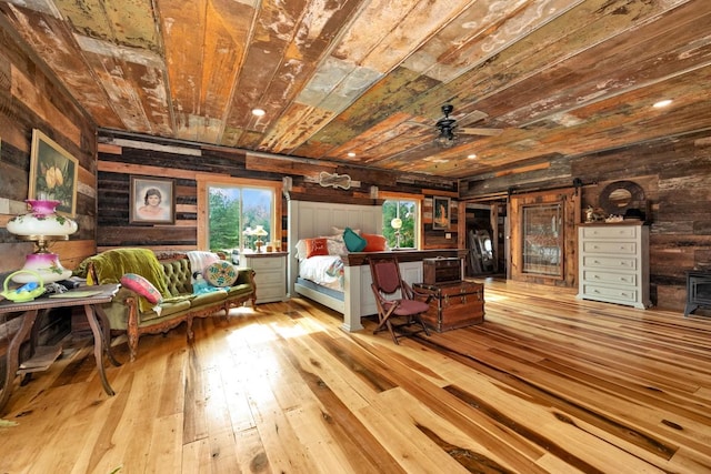 700 Kincaid Rd, Minor Hill, TN 38473 - bedroom with wooden walls, a barn door, a wood stove, hardwood / wood-style floors, and wood ceiling