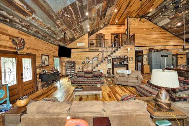 living room featuring high vaulted ceiling, wood walls, wood-type flooring, and beamed ceiling