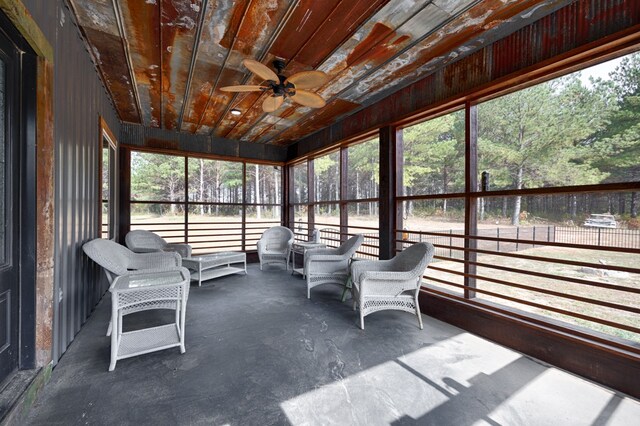 unfurnished sunroom featuring ceiling fan