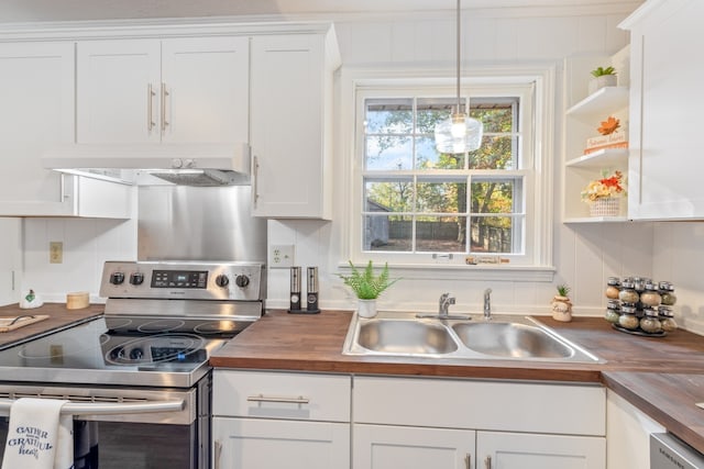 kitchen featuring stainless steel electric stove, white cabinetry, sink, and butcher block countertops