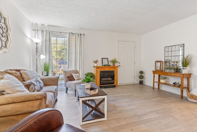 living room with light hardwood / wood-style floors and a textured ceiling