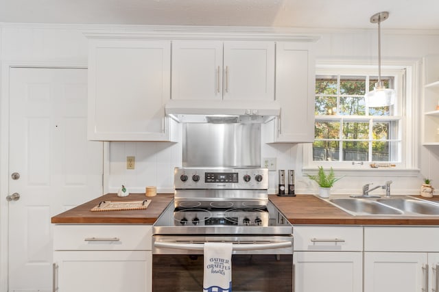 kitchen featuring butcher block countertops, stainless steel range with electric stovetop, pendant lighting, and white cabinets