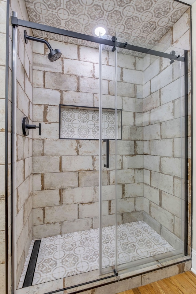 bathroom with wood-type flooring and an enclosed shower