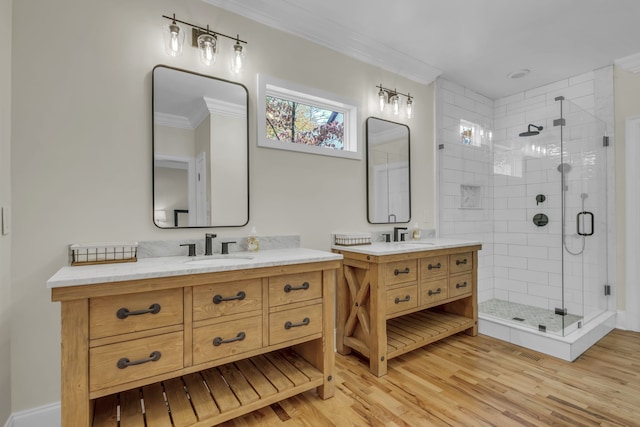 bathroom with vanity, crown molding, hardwood / wood-style floors, and a shower with door