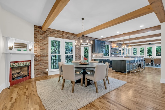 dining space with light hardwood / wood-style flooring, a healthy amount of sunlight, and beamed ceiling