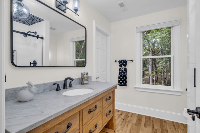 bathroom with vanity, walk in shower, wood-type flooring, and plenty of natural light