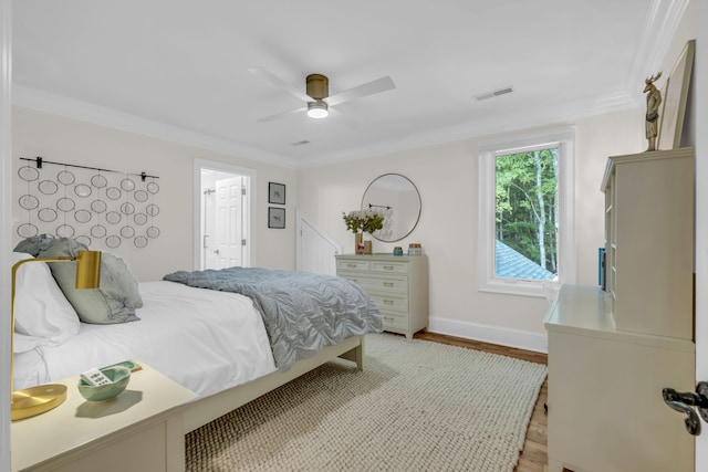 bedroom with light hardwood / wood-style flooring, crown molding, and ceiling fan