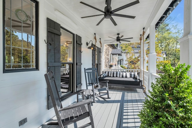 wooden deck featuring covered porch and ceiling fan