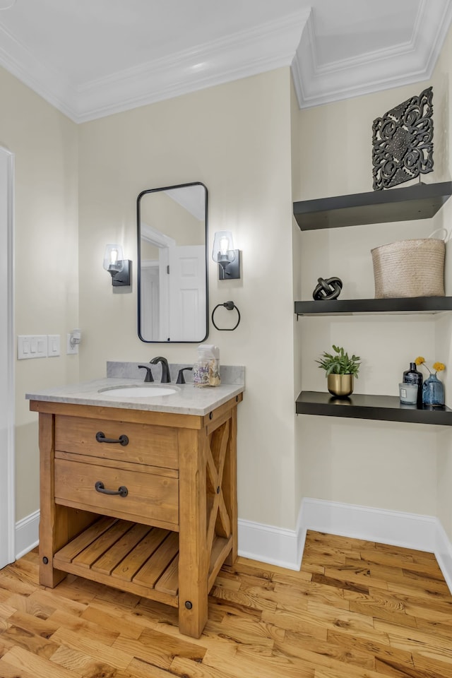 bathroom featuring vanity, ornamental molding, and wood-type flooring