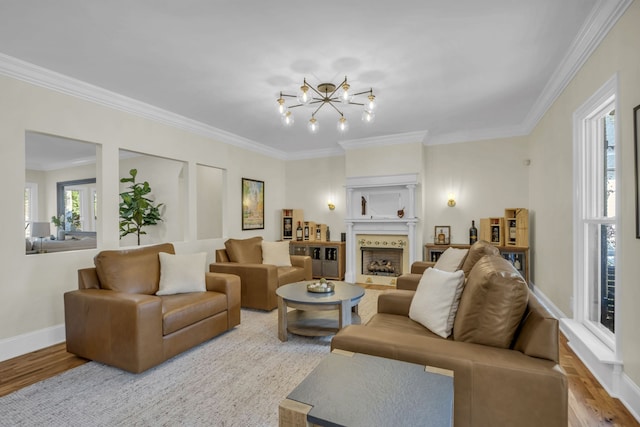 living room with ornamental molding, a chandelier, and light hardwood / wood-style floors