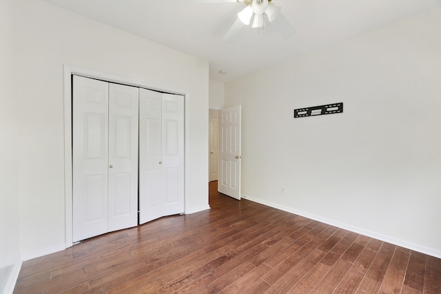 unfurnished bedroom with dark wood-type flooring, ceiling fan, and a closet