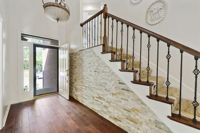 entryway with a high ceiling and dark hardwood / wood-style flooring