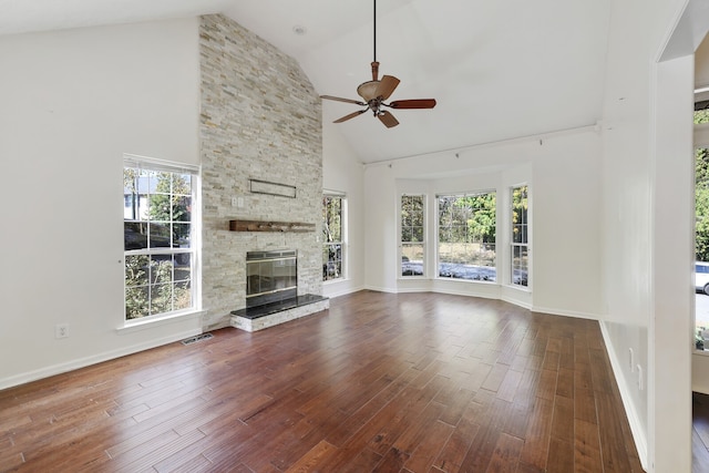 unfurnished living room with a healthy amount of sunlight, high vaulted ceiling, a fireplace, and dark hardwood / wood-style flooring