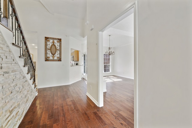 hall featuring dark wood-type flooring and a chandelier