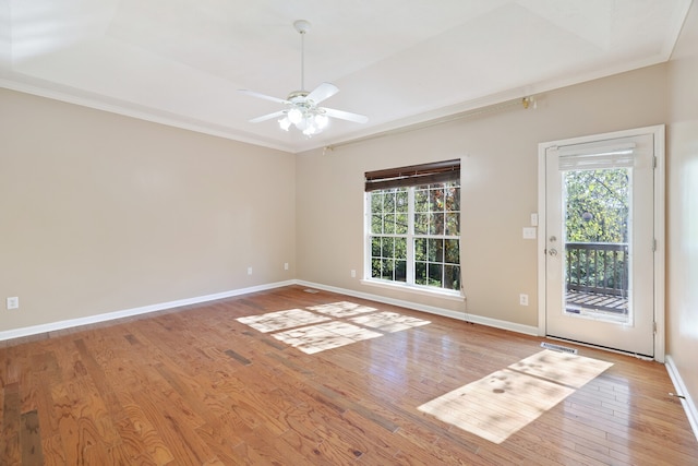 empty room with ceiling fan, ornamental molding, and light wood-type flooring