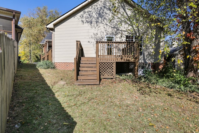 rear view of property with a yard and a deck